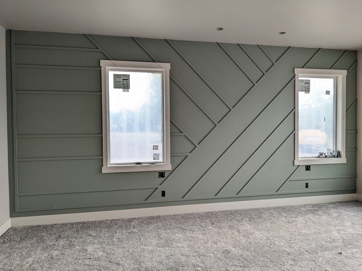Geometric board-and-batten accent wall built around two windows