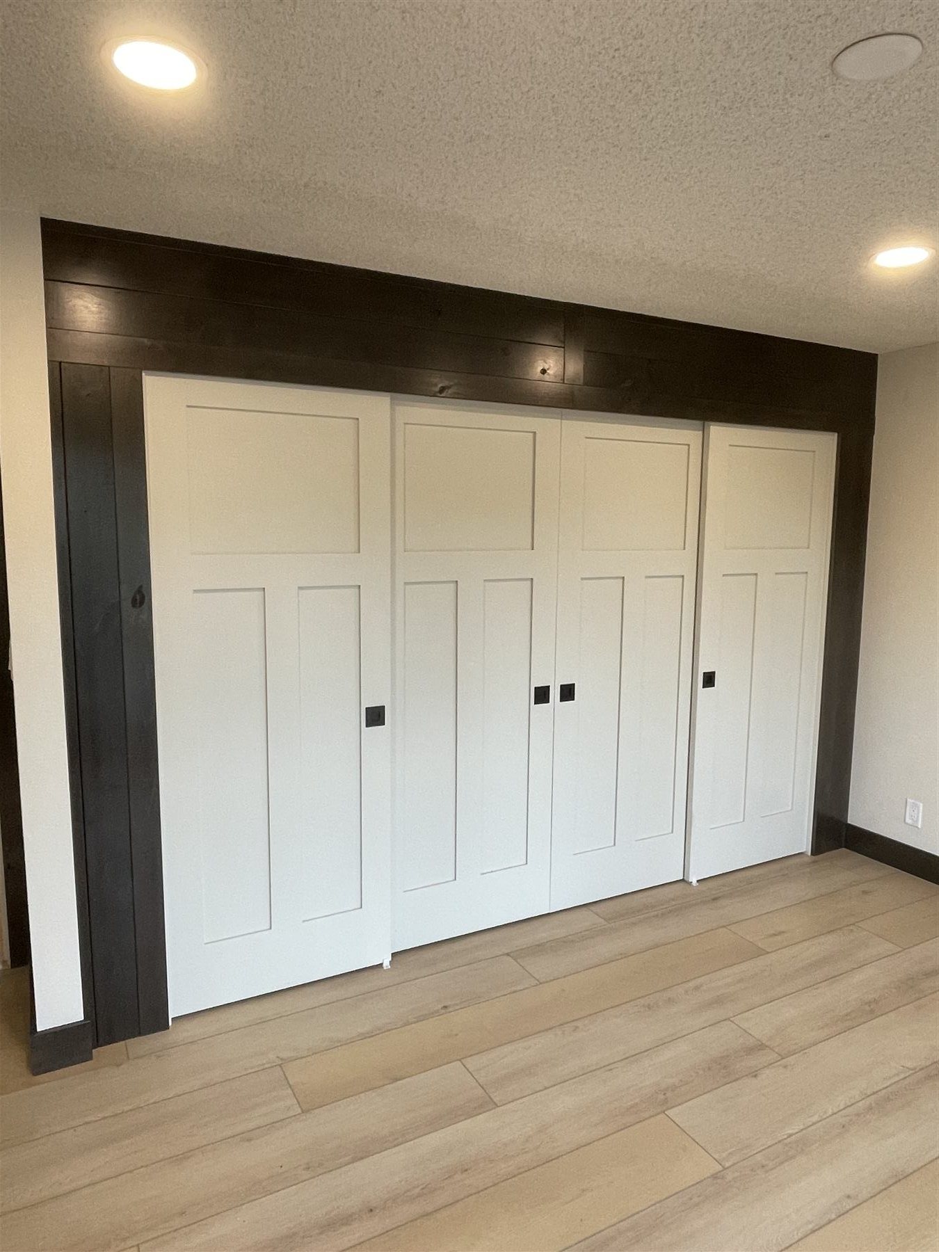 Craftsman-panel sliding closet doors framed in dark stained trim