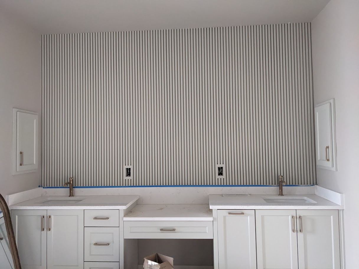 Fluted panel accent wall above a bathroom double vanity