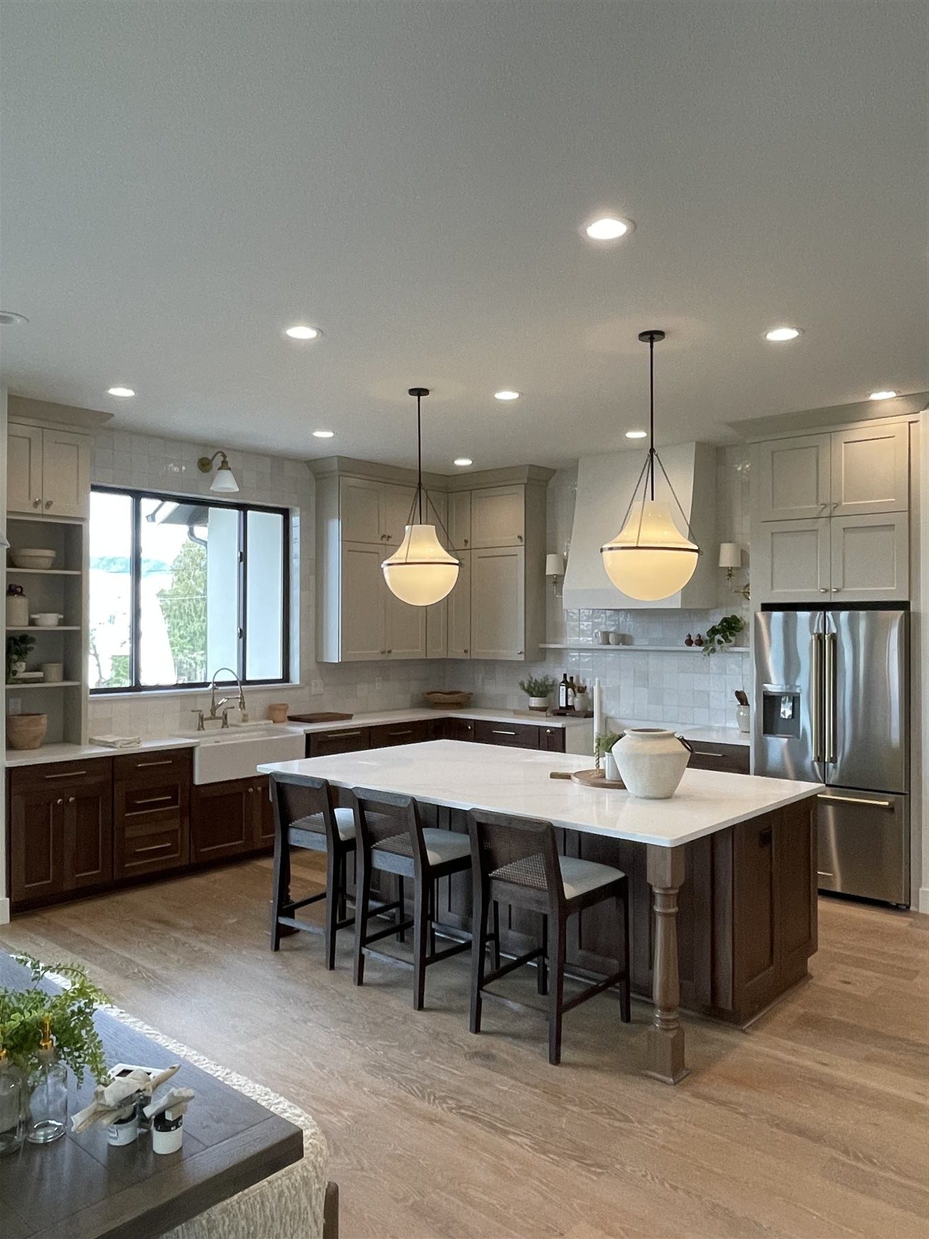 Full kitchen view with white cabinetry, marble mosaic backsplash, and stone island