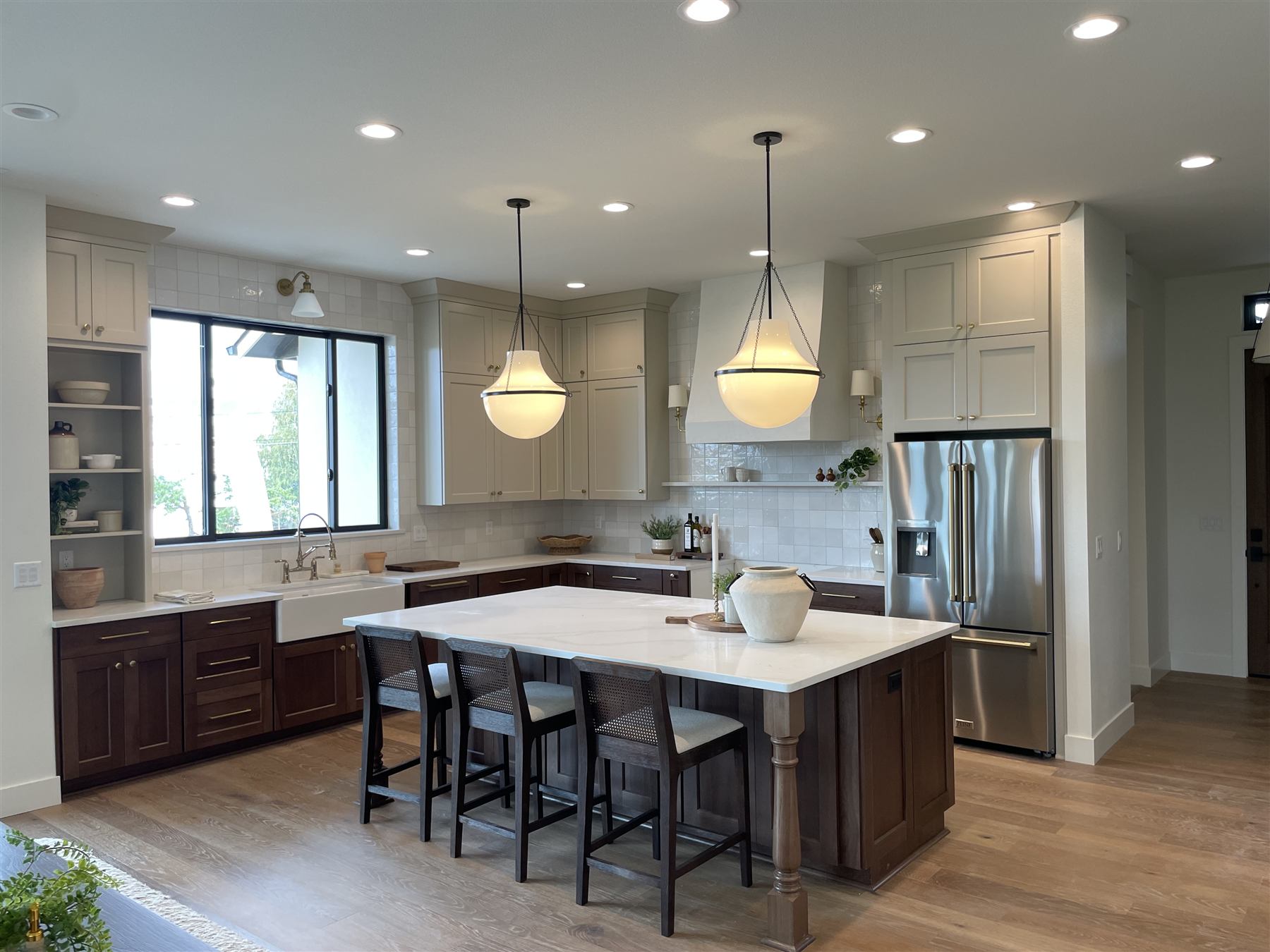 Finished kitchen from a second angle, white cabinetry and marble mosaic backsplash