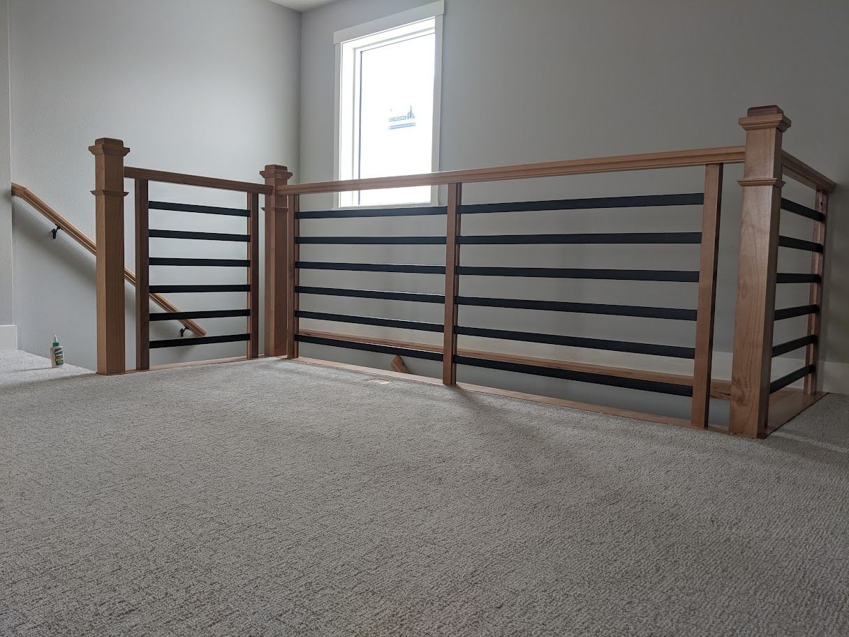 Loft railing with wood posts and black horizontal metal accents