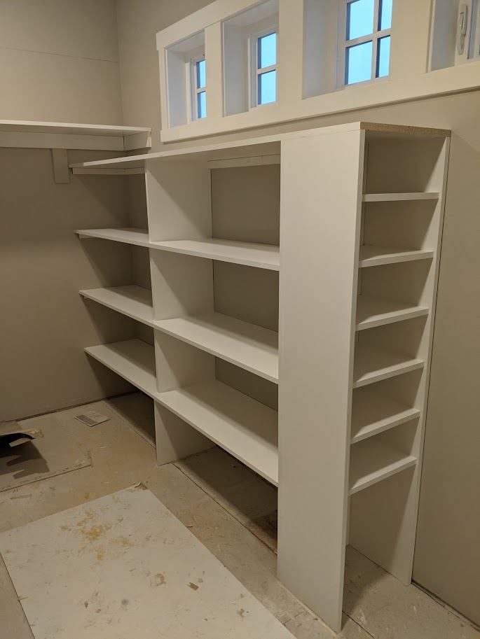Pantry shelving tower being installed near a window