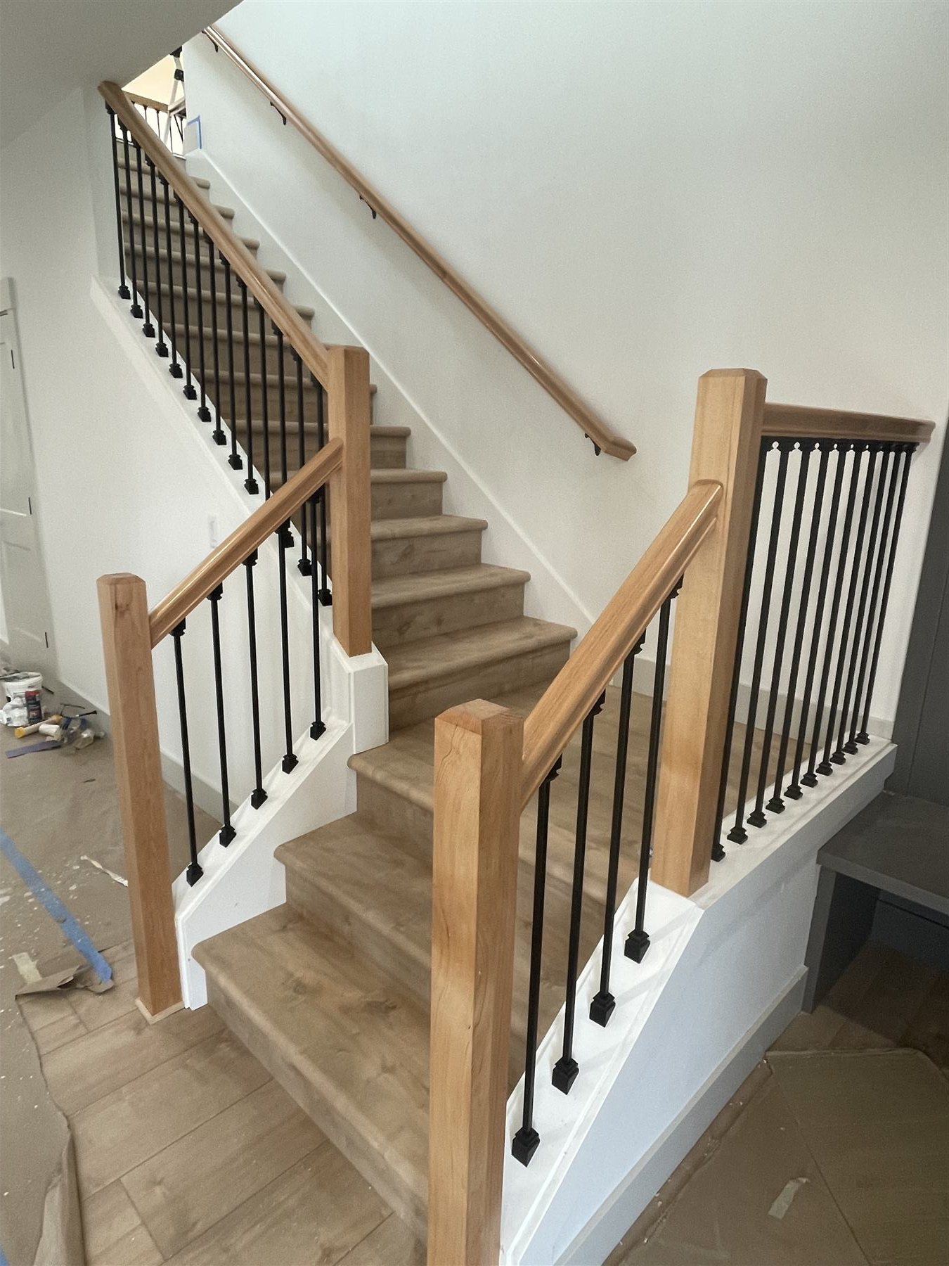 Staircase with wood rail and black balusters