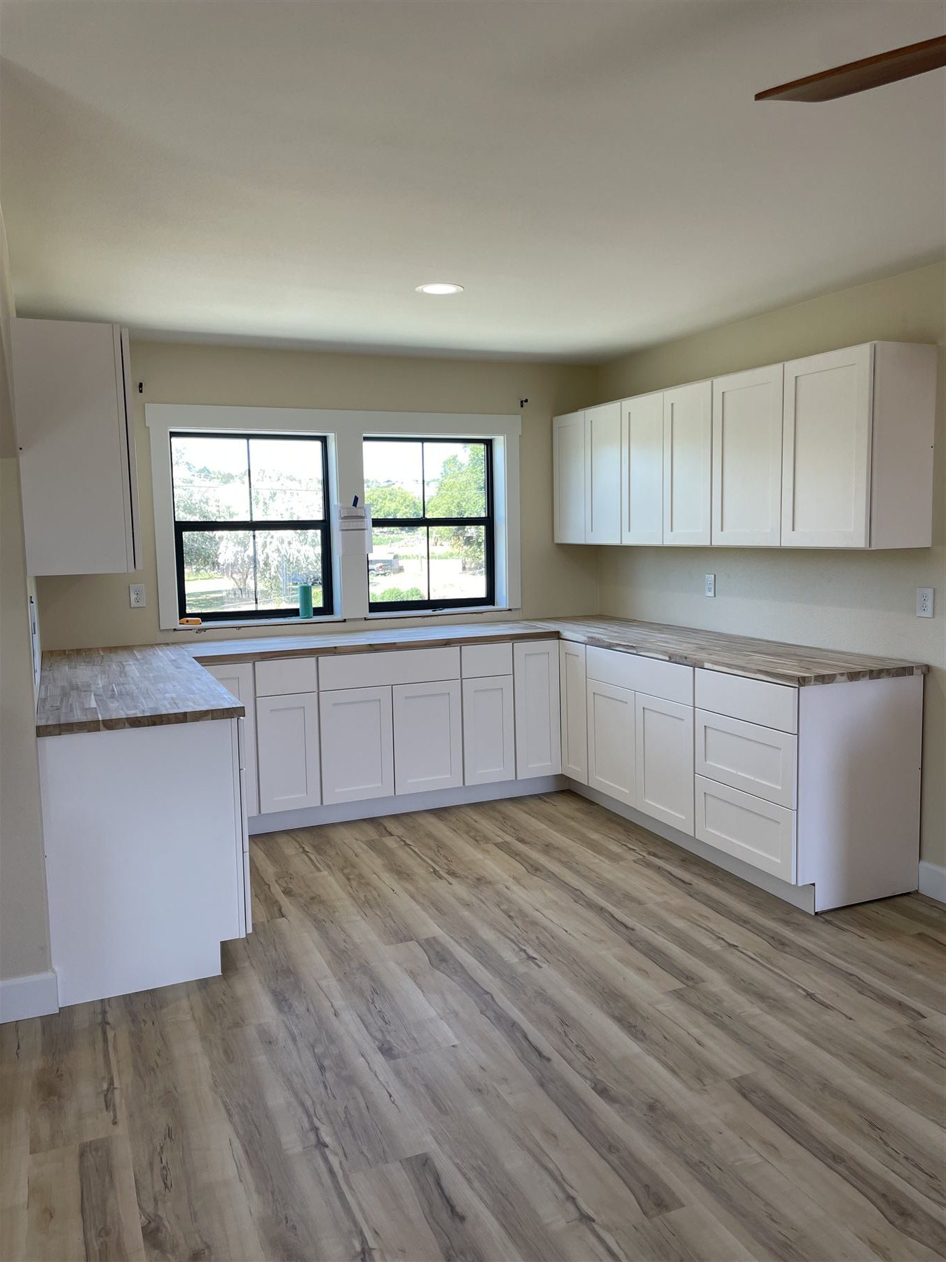 Kitchen corner with white shaker cabinets and butcherblock counters