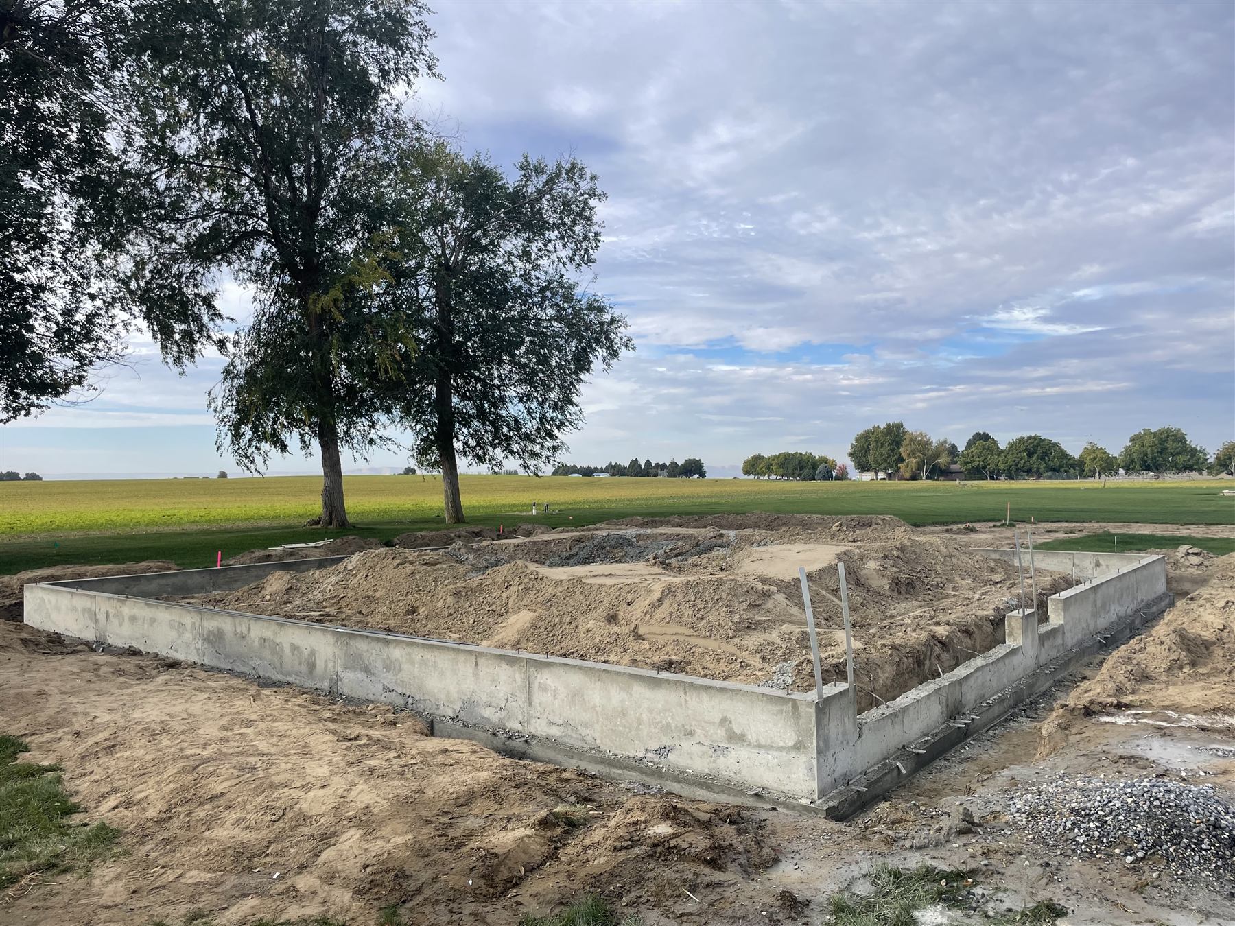 Poured concrete foundation footings outlined on a rural building lot