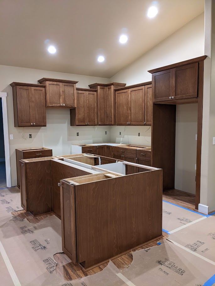Custom stained kitchen cabinetry with a large island, freshly installed