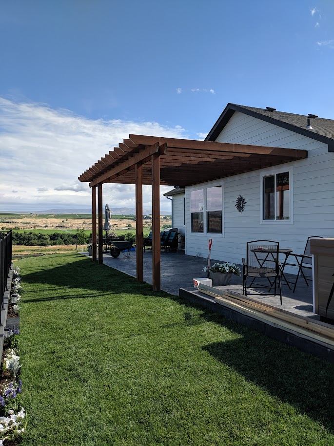 Finished cedar pergola over a concrete patio with a sweeping valley view