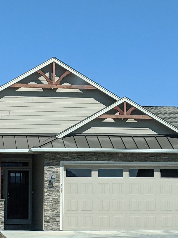 Finished addition entry with stone accent and timber gable brackets