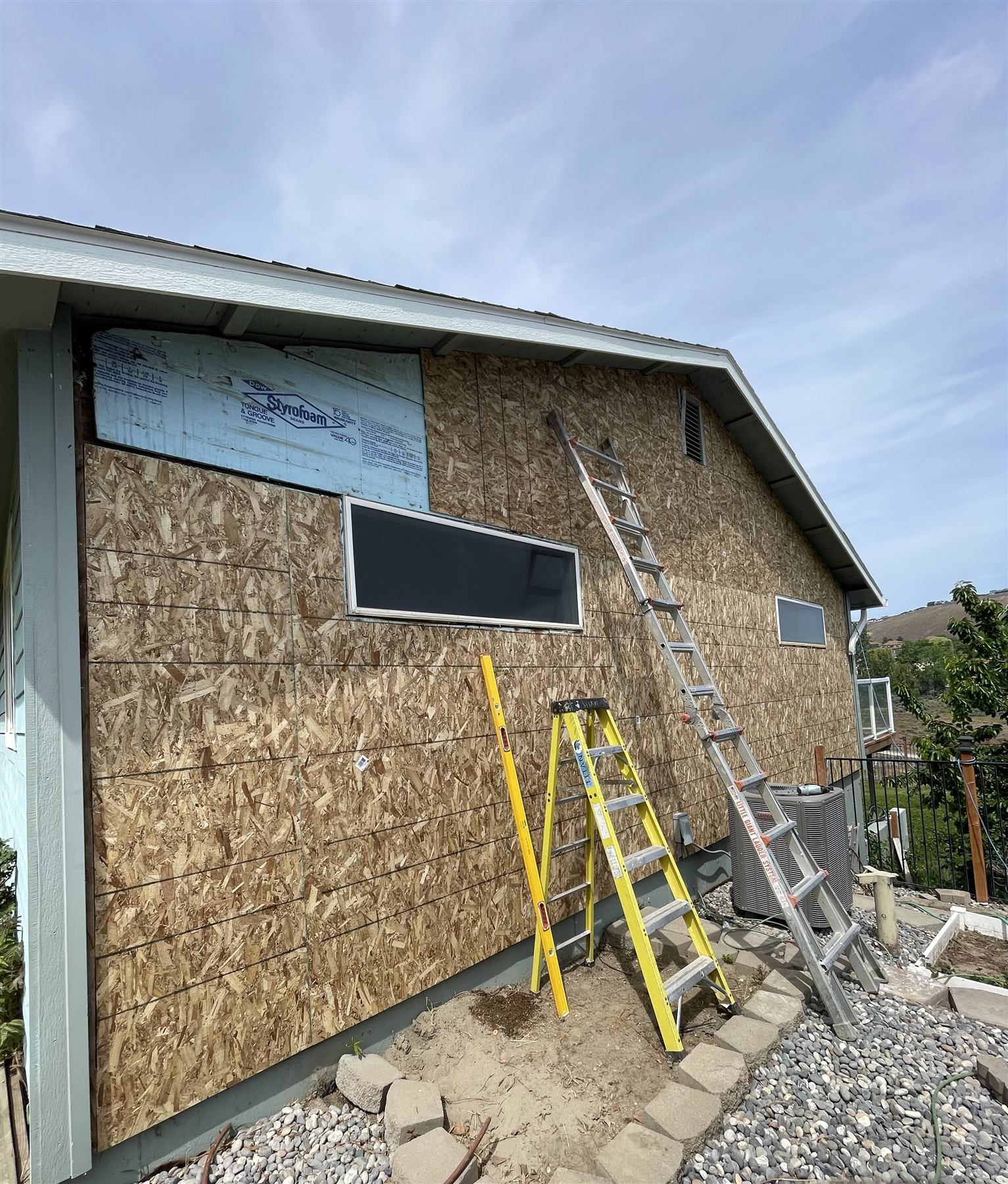 House exterior mid-reside with old siding removed down to sheathing