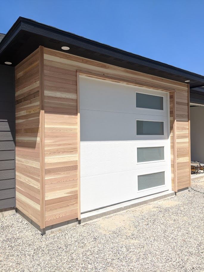 Finished modern garage addition with cedar plank siding and a white door