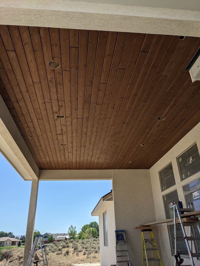 Natural-finish wood patio cover ceiling mid-installation