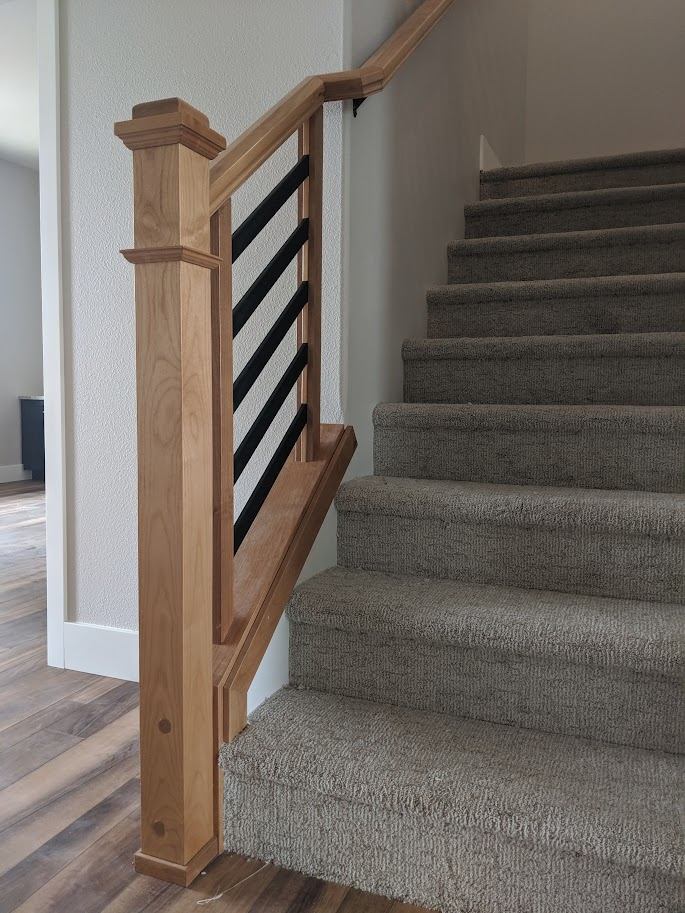 Custom wood stair railing with a paneled newel post